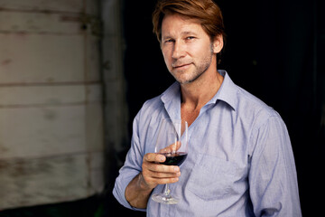 Portrait, wine tasting and a man in the cellar of a vineyard on a farm for the production or...