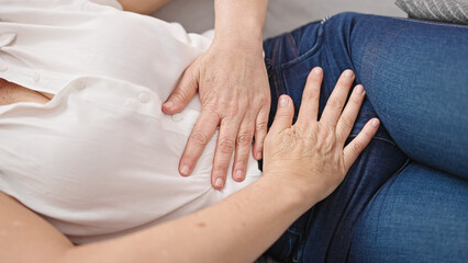Fototapeta na wymiar Middle age hispanic woman suffering for menstrual pain lying on sofa at home
