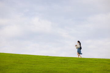 Woman with her dachshund dog walking in the park