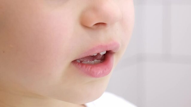 The mouth of a talking child. Saying boy. Milk and molars teeth. Beautiful smile. Close-up. Gesticulation. Speech apparatus. Cute 6 year old child caucasian appearance with white skin and pink lips.