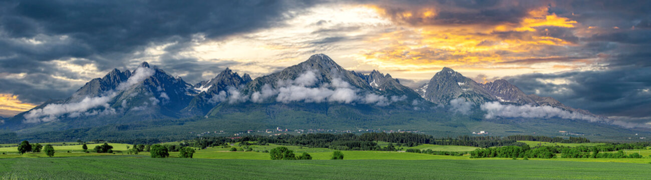 Panoramic view of Tatra mounains. Landscape of High Tatras in the spring. Snowy mountain tops and beautiful sky.