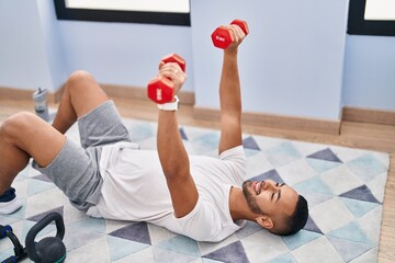 African american man using dumbbells training push up at home