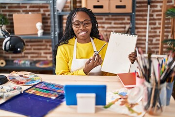 African american woman artist having online paint lesson at art studio