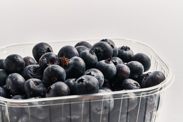  Delicious group of blueberries on plastic box over isolated white background