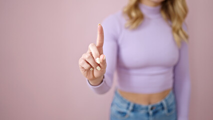 Young beautiful hispanic woman saying no with finger over isolated pink background