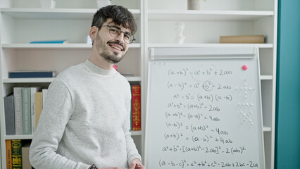 Young hispanic man teacher teaching maths lesson at university classroom - obrazy, fototapety, plakaty