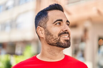 Young hispanic man smiling confident standing at street