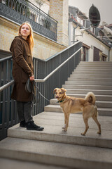 Beautiful blonde girl with dog in the city
