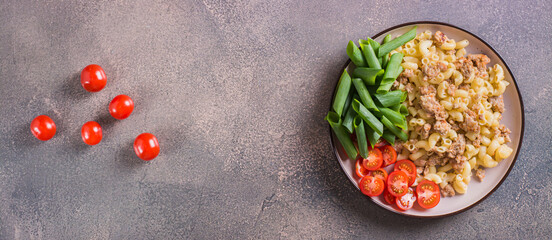 Naval pasta with cherry tomatoes and chives on a plate on the table top view web banner