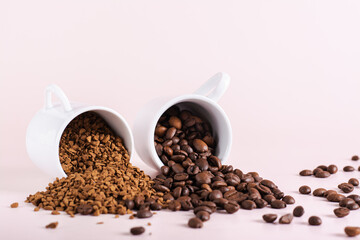 Dry instant coffee granules and roasted coffee beans are scattered from cups on the table