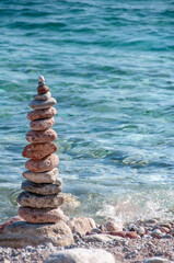 Fototapeta na wymiar Pyramid - stack of stones on seaside, zen meditative pebbles on the beach