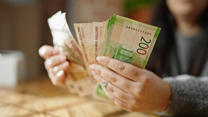Hands of woman counting russian ruble banknotes at room