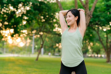 Female jogger. Fit young Asian woman with green sportswear stretching muscle in park before running and enjoying a healthy outdoor. Fitness runner girl in public park. Wellness being concept