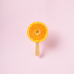 Raw fruit oranges on an ice cream stick. Creative summer concept.