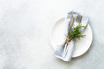 Table setting, serving on white. White plate, cutlery and napkin. Flat lay image with copy space.