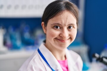 Young woman with down syndrome scientist smiling confident standing at laboratory