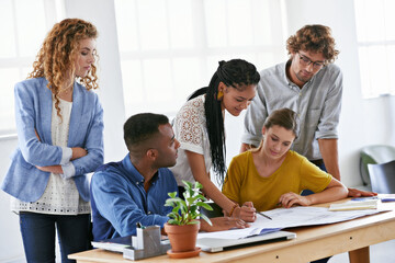 Obraz premium Diversity, business people and writing on blueprint in planning, brainstorming or design at the office. Architect group working on document, floor plan or strategy for construction at the workplace
