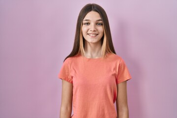 Fototapeta premium Teenager girl standing over pink background with a happy and cool smile on face. lucky person.