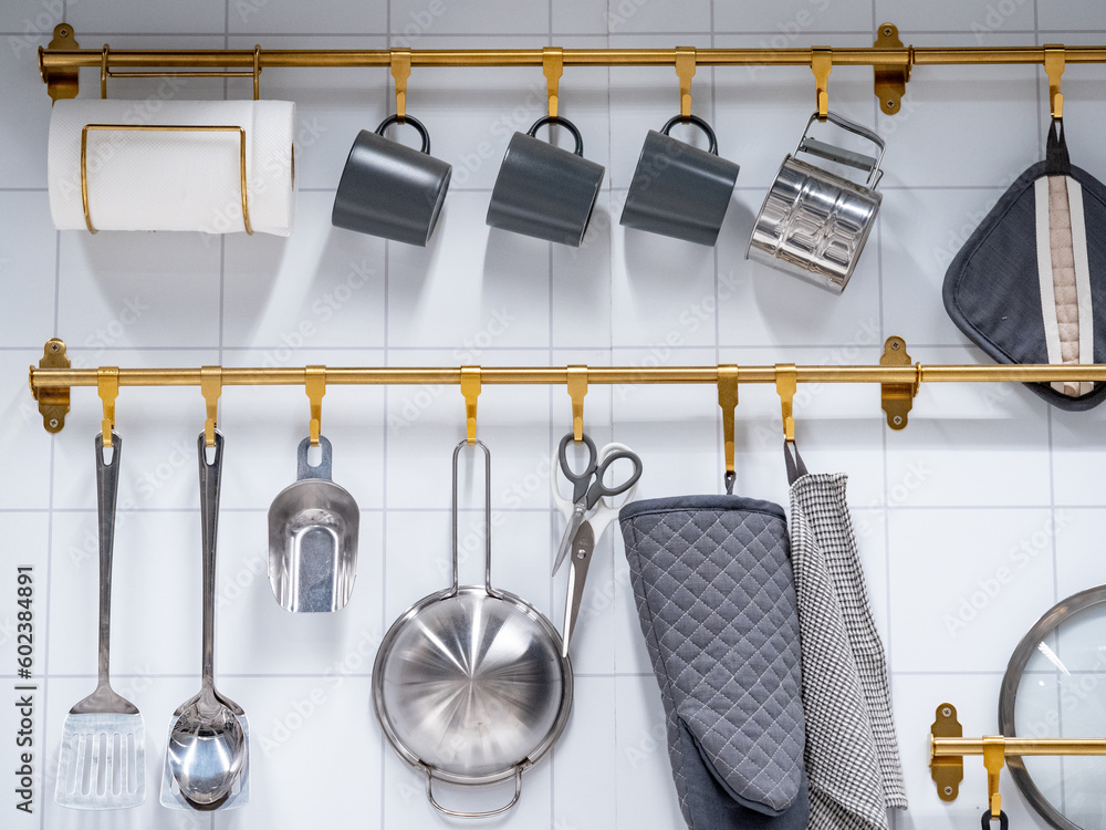 Wall mural Group of hanging kitchenware and tableware accessories display on the wall in the kitchen utensil store.