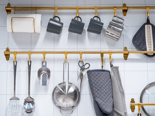 Group of hanging kitchenware and tableware accessories display on the wall in the kitchen utensil...