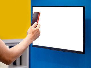 Male customer using smartphone scanning QR code on Interactive digital monitor for searching goods information in department store. Blank white screen for mockup