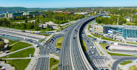 Multilevel city highway junction in Krakow, Poland. One highway on the top level, the second one in the tunnel, the turnaround with traffic lights and zebra crossings on the middle level. Aerial view - 602388087