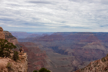 Woman with scenic view from Skeleton Point on South Kaibab hiking trail at South Rim, Grand Canyon National Park, Arizona, USA. Colorado River weaving through valleys and rugged terrain. O Neill Butte