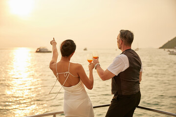 back couple drinking orange juice in luxury yacht