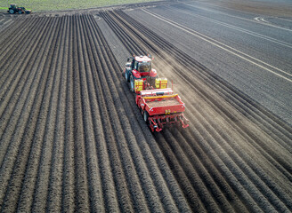 Moderne Landtechnik wird eingesetzt beim legen der Saatkartoffeln - Luftbild - Traktor mit...