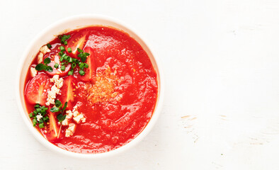 Tomato soup on white table, top view