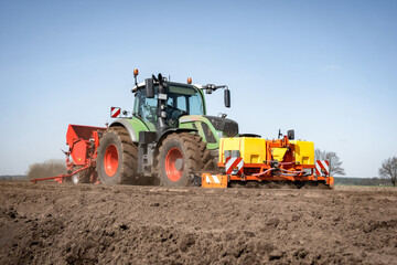 Moderne Landtechnik für die Bestellung des Katoffelackers im Einsatz -  Traktor mit Kartoffellegemaschine.