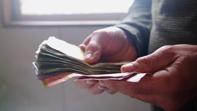 man holding, counts lot of national currency of Sri Lanka, paper money bills Rupee banknotes, devaluation, high inflation of state, exchange rate on travel, vacation, savings, banking, tax payment