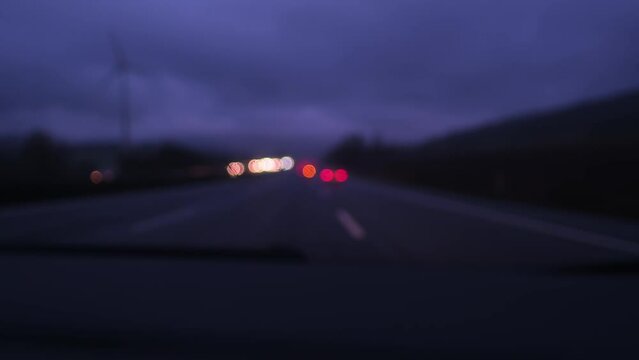 blurred traffic of cars that are driving fast on road expressway at night in rain in Germany, blurry lights move smoothly in the dark, background for designers, travel concept, evening traffic