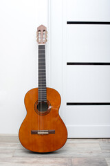 Obraz premium A guitar is leaning against a white wall