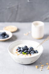 Rice porridge on coconut milk with blueberries and nuts on a gray background. Healthy breakfast, healthy food