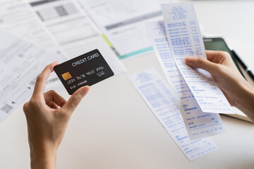 Financial owe, hand of asian woman sitting, holding credit card, stressed  by calculate expense from invoice or bill, no money to pay, mortgage or loan. Debt, bankruptcy or bankrupt.