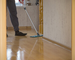 Washing the parquet floor with a mop in the maid 's apartment . The concept of routine household chores