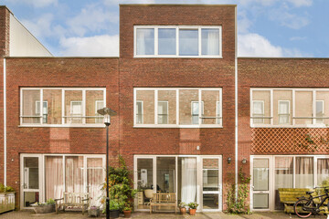 an apartment building with bicycles parked on the street in front of it and blue sky overhead above, as seen from outside