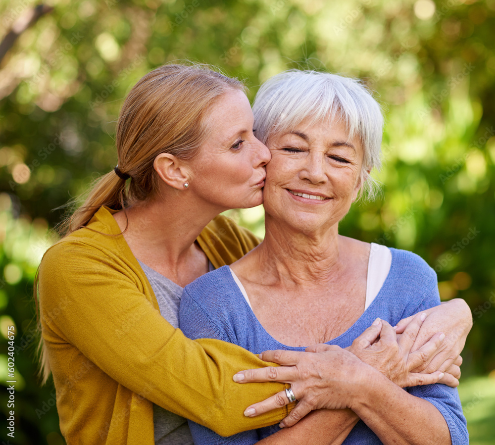 Wall mural Adult daughter kiss mom, hug and trust with peace outdoor, family spending quality time in garden together. Women are content in relationship with love, bonding and solidarity in nature park