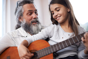 Girl with grandfather, happy with guitar and learning to play, music education and creative...