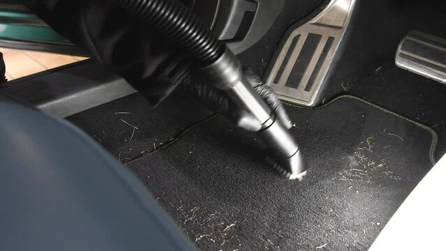 cleaning the car interior with a car vaccum cleaner espaccialy vaccuming the footwell