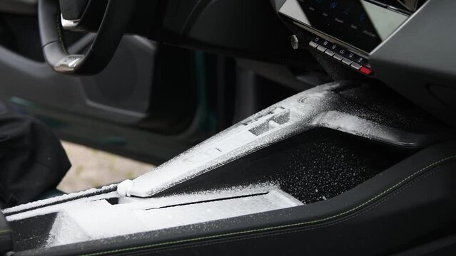 interior car detailing and cleaning with foam, brush and microfiber. spraying of cleaning foam and cleaning with the brush and microfiber afterwards.