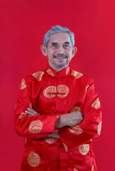 portrait asian senior man with grey hair and beard in traditional chinese clothes isolated on red background