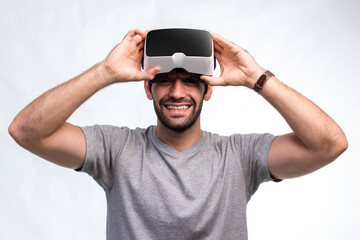 Naklejka premium Man in VR headset. Man using VR glasses for online game. Handsome man using virtual reality headset. man experience virtual reality via VR headset and touching something with hands.
