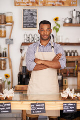 Black man, portrait and waiter with arms crossed in cafe with pride for career or job. Barista, serious and confidence of African person from Nigeria in restaurant, small business and coffee shop.