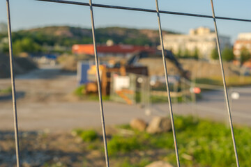 Close-up focus on fences with a construction site in the background