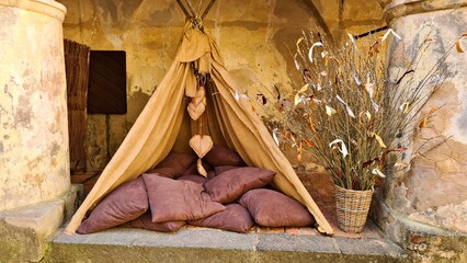 Obraz premium An impromptu small hut with many pillows against stone wall