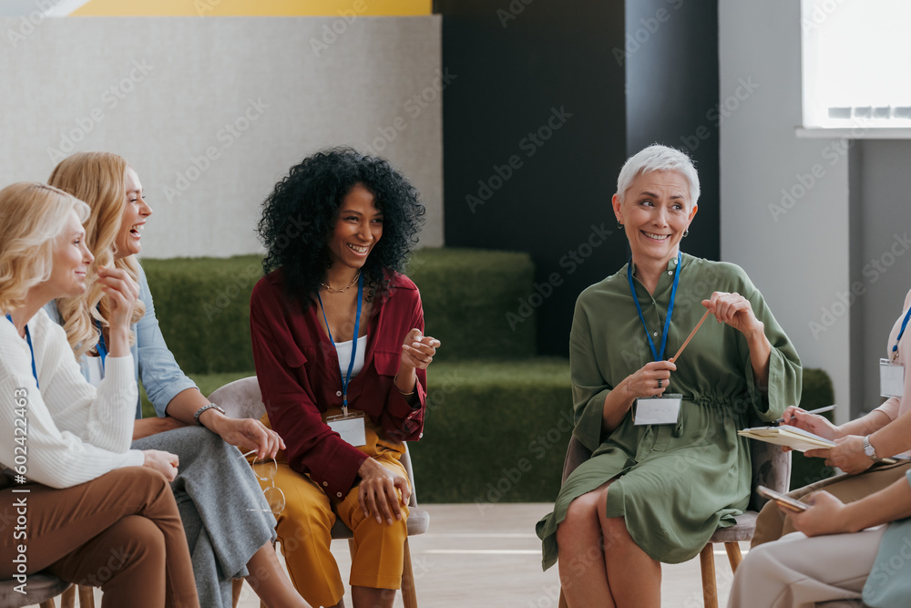 Wall mural Confident mature women communicating and smiling while visiting group training class