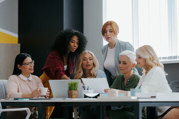 Group of confident mature women discussing business in the office together