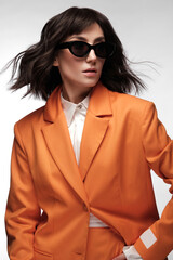 Spectacular beautiful woman in a trendy orange suit with classic make-up. Beauty face.